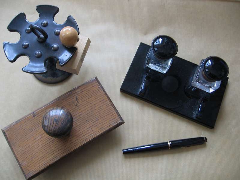 Stempelträger, Stempelkissen, Stift und Stempel auf einem Schreibtisch